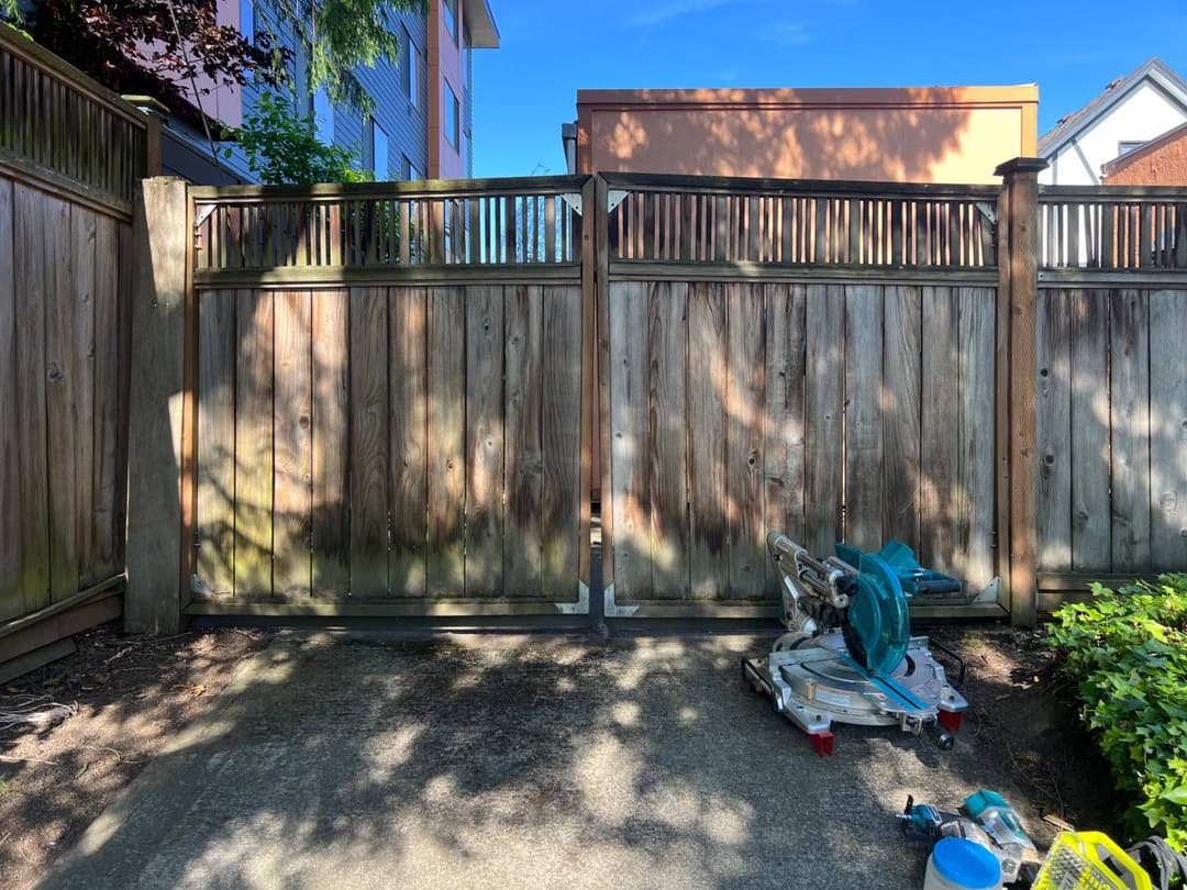 Completed privacy fence with gate installed in suburban backyard