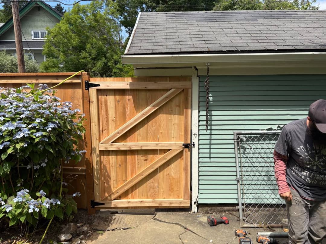 Custom wood gate installation attached to existing fence