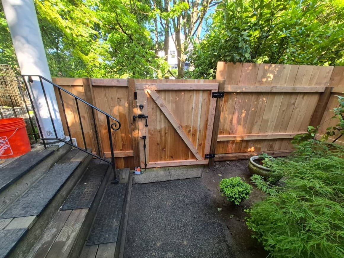 Custom wood gate and fence installation in a residential backyard
